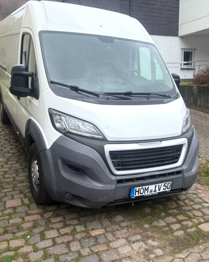 Weißer Transporter von Intercity Verleih mit Kennzeichen HOM IV 50 auf Kopfsteinpflaster