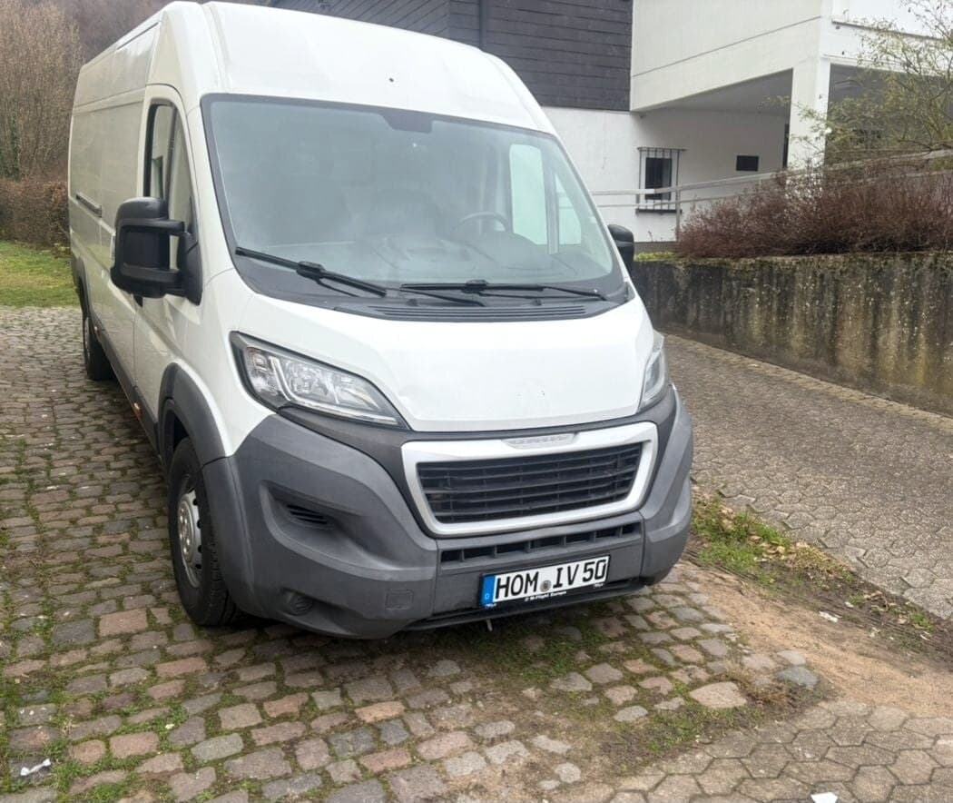 Weißer Transporter mit dem Kennzeichen HOM IV 50 auf Kopfsteinpflaster, Frontansicht